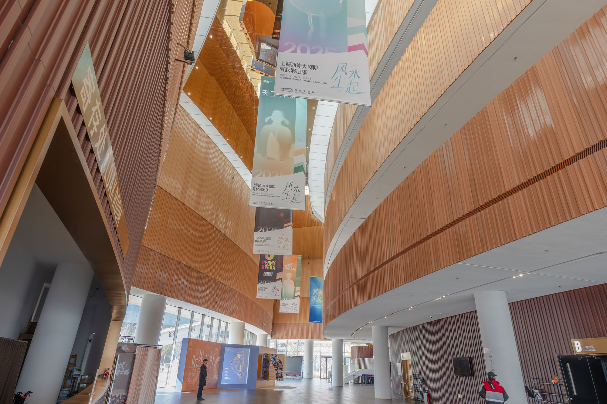 Overall lobby view with continuous terracotta wall surfaces.