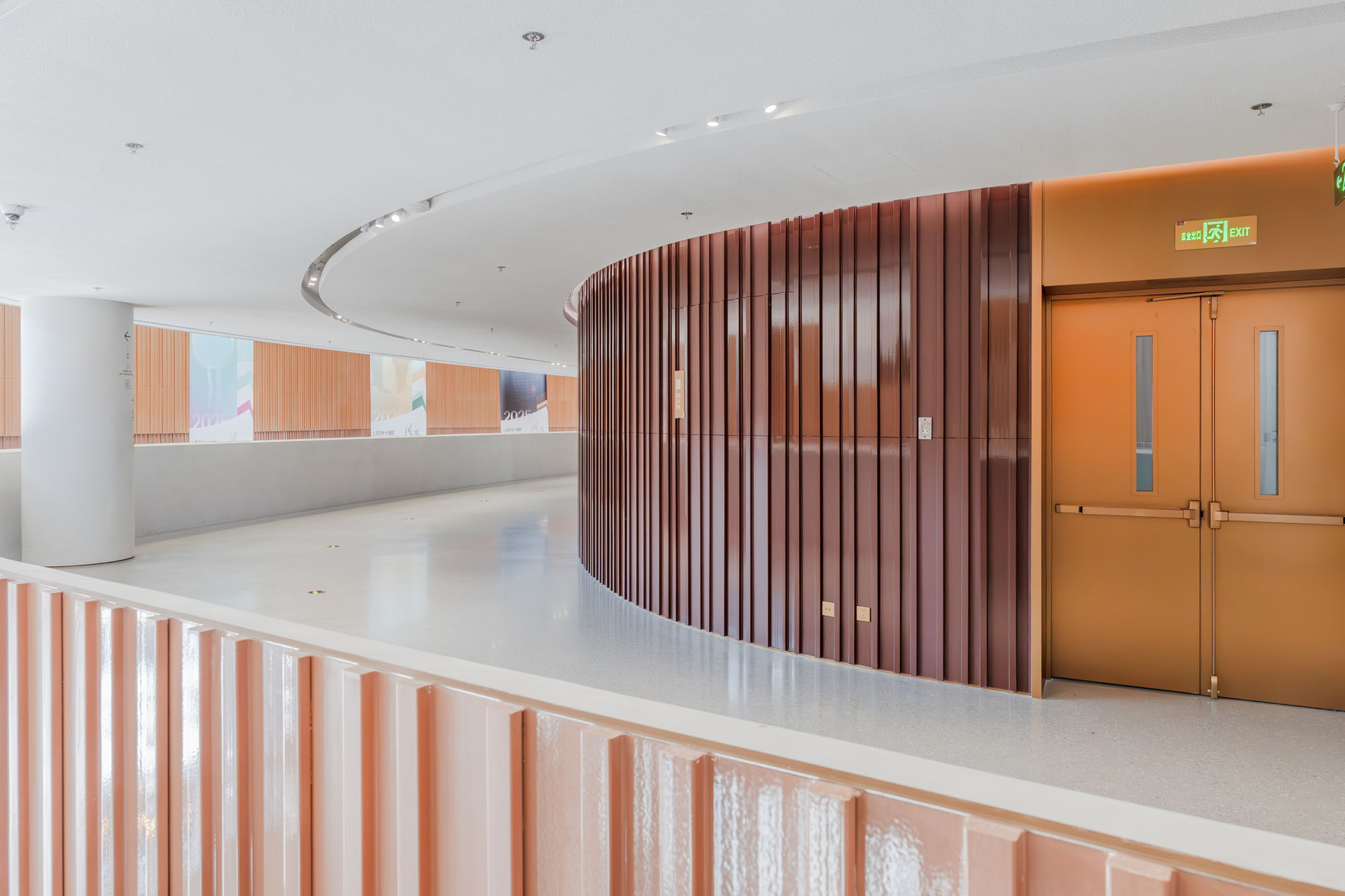 Profiled terracotta wall panels in a public corridor.