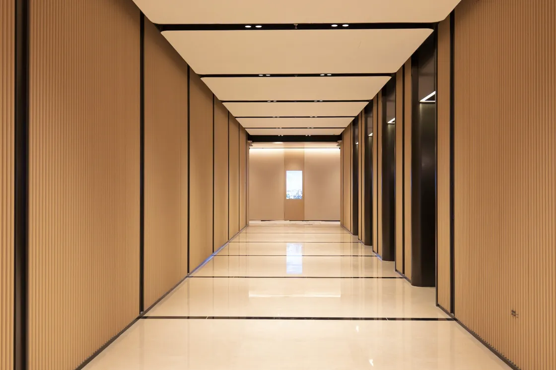 Long corridor at EIC Super Innovation CBD with vertically ribbed yellow terracotta walls and repeating ceiling panels.