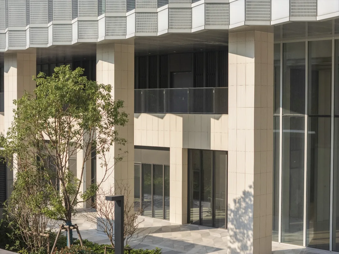 Bofeng Center exterior façade with pale terracotta cladding, columns and adjacent glazing.